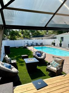 a patio with chairs and a table and a pool at Newly Reno - Backyard Oasis, South Tampa Pool Home in Tampa