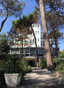 um edifício de escritórios com árvores em frente em Hotel Promenade em Milano Marittima