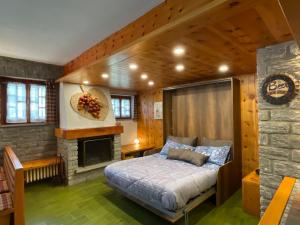 a bedroom with a bed and a fireplace at Villa La Roccia Scopello Valsesia in Scopello