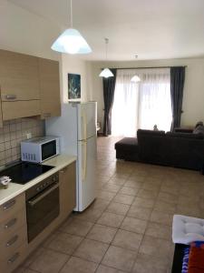 a kitchen with a white refrigerator and a living room at Harmonia at Gennadi Court in Gennadi