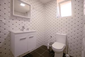 a bathroom with a toilet and a sink and a window at Arber's Home in Sarandë +10 photos