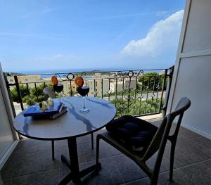 a table with two glasses of wine on a balcony at Pansion Komfor Moča in Makarska