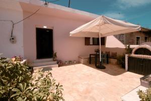 a patio with an umbrella in front of a house at Arber's Home in Sarandë