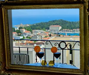 una ventana con vistas a la ciudad y copas de vino en Pansion Komfor Moča, en Makarska