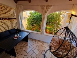 a living room with a hammock in front of two windows at Apartments Villa Julija in Lumbarda