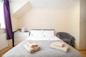 Un dormitorio con una cama con toallas. en Comfy private room in Battersea close to Clapham Junction, en Londres