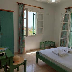 Schlafzimmer mit einem Bett, einem Schreibtisch und einem Fenster in der Unterkunft HOTEL KAPARI in Agia Anna