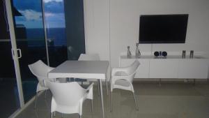 een witte eetkamer met een witte tafel en stoelen bij Apartamento Los Morros in Cartagena