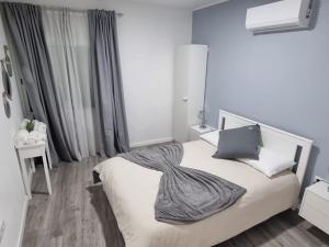 una camera da letto con un letto bianco con una coperta sopra di Casa Pereira 2 a Ponta do Pargo