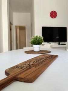 a wooden cutting board on a table with a plant at Casa Kaukana - A Pochi Passi dal Mare in Villaggio Azzurro