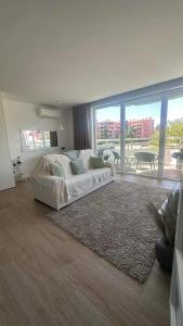 een witte bank in een kamer met een groot raam bij Golden Coast Residence in Portimão