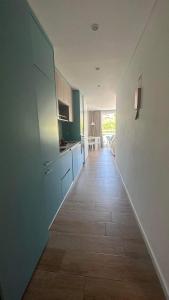 een gang die leidt naar een keuken met blauwe kasten bij Golden Coast Residence in Portimão