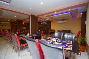 uma sala de jantar com mesas e cadeiras em OYO Kingstar Resort em Pānāgarh
