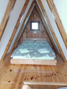 a bed in the attic of a tiny house at Bungalows and rooms Ivan in Žabljak