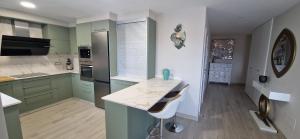 a kitchen with green cabinets and a white counter top at Nacimar in O Grove