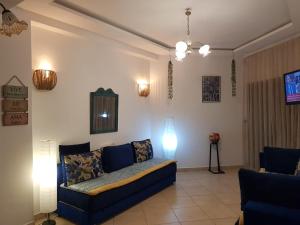 a living room with a blue couch and two lamps at Beralmar in Asilah