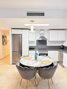 a kitchen with a table and chairs in a room at La Recoleta Residence Punta Prima in Torrevieja