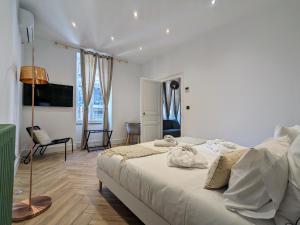 a bedroom with a large white bed in a room at My'Deting - Jacuzzi in Roanne
