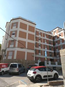 a parking lot with cars parked in front of a building at Habitacion centrica con baño privado in Portbou