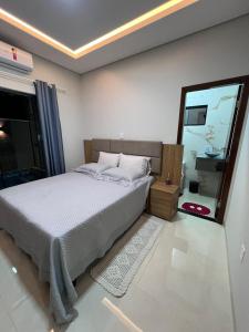 a bedroom with a bed and a large window at Casa Suítes Beach in Vilhena +53 photos