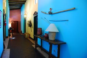 Habitación con pared azul y mesa con lámpara. en Hotel Portal del Angel en Tegucigalpa