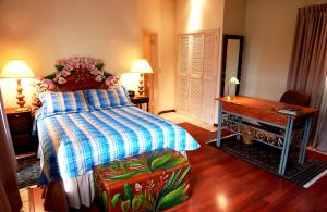 a bedroom with a bed and a desk and a piano at Hotel Portal del Angel in Tegucigalpa
