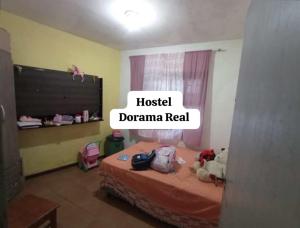 una camera da letto con un cartello che legga i drammi dell'ospedale di Hostel Dorama Real a Mongaguá