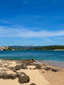 vistas a una playa con un puente en el fondo en Pirata Milfontes Guest House, en Vila Nova de Milfontes