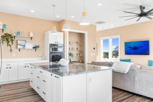a kitchen with white cabinets and a large island at Salt & Lime in North Topsail Beach