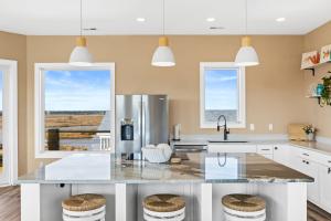 a kitchen with a large island with two windows at Salt & Lime in North Topsail Beach