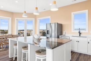 a kitchen with a large island with a refrigerator at Salt & Lime in North Topsail Beach
