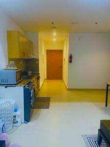 an empty kitchen with a red door in a room at Emirates apartment in Dubai