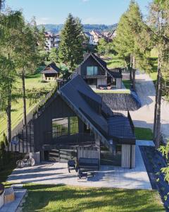 an overhead view of a house with a black roof at Trzy Szyszki Maniowy Domki Jezioro Czorsztyńskie Balia oraz Sauna w cenie in Maniowy