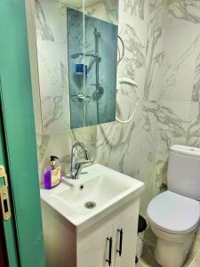 W łazience znajduje się umywalka, toaleta i lustro. w obiekcie Otel Kadıköy w Stambule