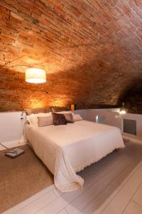 Un dormitorio con una cama grande en una pared de ladrillo. en The eyes of Peccioli, en Peccioli 20 fotos más