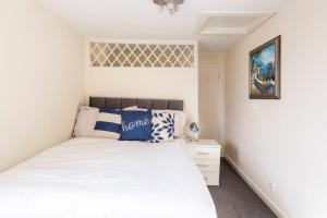 a bedroom with a white bed with blue pillows at The Hideaway, lovely cosy place in Blandford Forum, Dorset in Blandford Forum