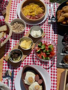 una mesa con platos de comida en un paño de mesa blanco y rojo en Helga's Guesthouse en Lin