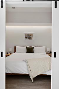 a white bedroom with a large bed with white pillows at Modern Lifestyle Loft with View - Zuni Lofts in Denver