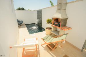 a view of a patio with a fireplace and a chair at VILLA LUXURY MARIA in Roche +8 photos
