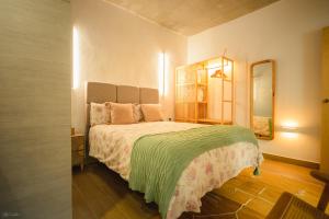 a bedroom with a large bed with a green blanket at VILLA LUXURY MARIA in Roche