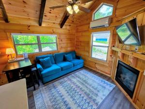 a living room with a blue couch and a tv at BMV7 Tiny Home village near Bretton Woods in Twin Mountain