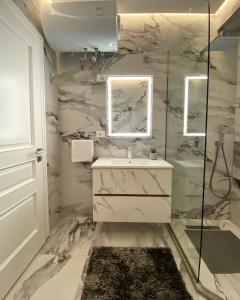 a white bathroom with a sink and a mirror at Luxury apartment with a wonderful lake view in Shkodër +30 photos