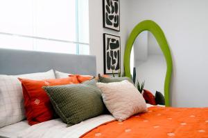 una camera con letto arancione e bianco con cuscini di The DACHA a Los Angeles