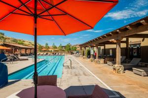 einem großen roten Regenschirm neben einem Pool in der Unterkunft Complete Luxury , Extras and Red Rock Vistas - Exclusive Golf Community in Sedona