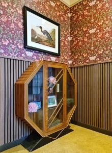 a wooden cabinet in a room with wallpaper at The Alyth Hotel in Alyth