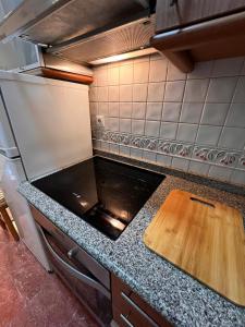 a kitchen with a wooden cutting board on a counter at Central Suites Isabel II in Vigo +7 photos