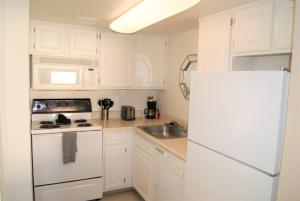 uma cozinha com armários brancos e um frigorífico branco em 216-Fully Furnished 1BR Suite-Outdoor Pool em Scottsdale