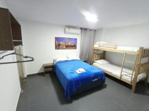 a bedroom with a blue bed and bunk beds at CASA HOTEL YEMI in Barranquilla