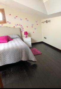 a bedroom with a bed with pink pillows at La casetta del Tuscolo -Secret rooms- in Grottaferrata