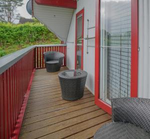 a deck with three chairs and a window at BärenNest Haus in Kirchheim